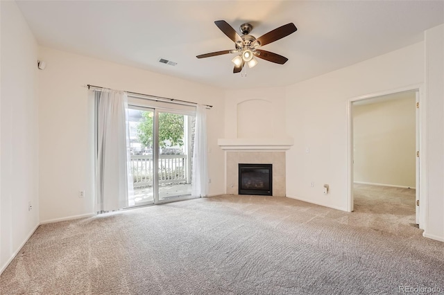 unfurnished living room with light carpet, a tiled fireplace, and ceiling fan