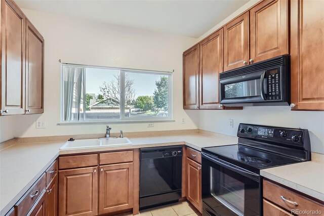 kitchen with light tile patterned flooring, sink, and black appliances