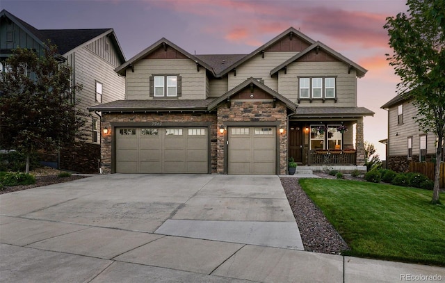 7949 S Elk Way, Aurora, CO 80016 - craftsman-style house with stone siding, driveway, a lawn, covered porch, and a garage