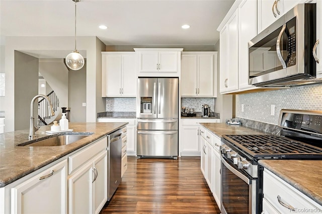 7949 S Elk Way, Aurora, CO 80016 - kitchen with stainless steel appliances, white cabinetry, stone counters, dark wood-style floors, and decorative backsplash