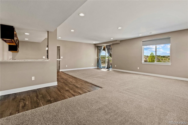 7949 S Elk Way, Aurora, CO 80016 - unfurnished living room featuring recessed lighting, carpet floors, and wood finished floors