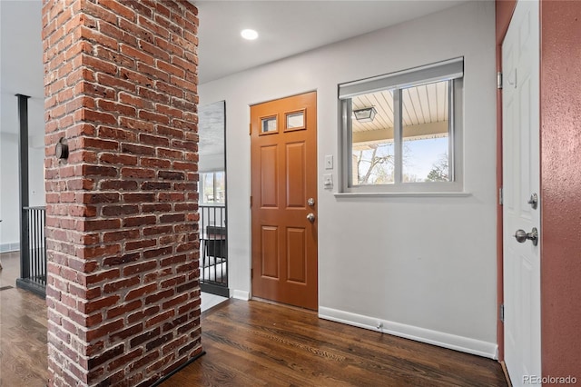 foyer with plenty of natural light, baseboards, and dark wood-style flooring
