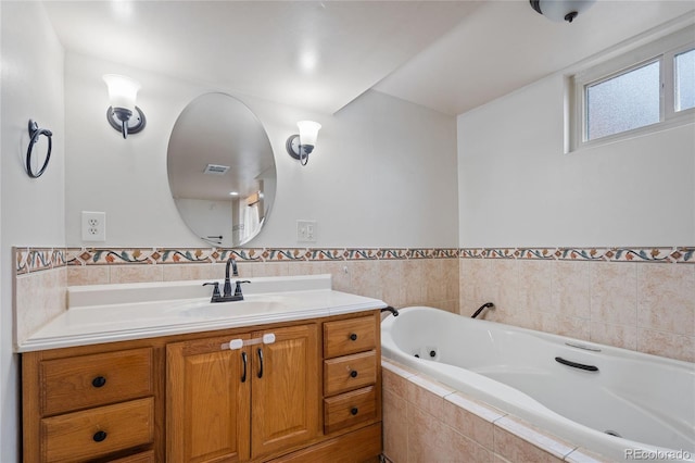 bathroom with wainscoting, a bath, vanity, and visible vents