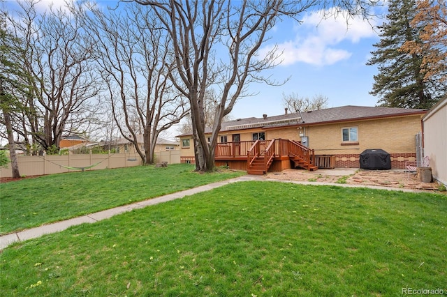 view of yard with fence, a deck, and stairway