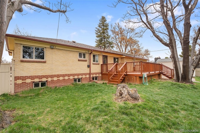rear view of house with a lawn, fence, a deck, and stairway
