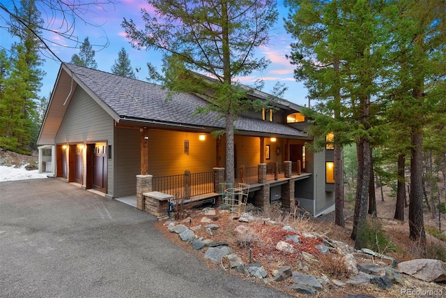 view of front of house with a shingled roof and a garage