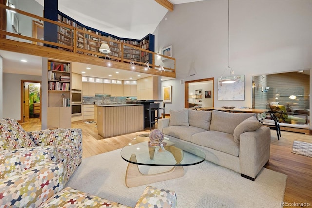 living room with light wood-style flooring and a towering ceiling