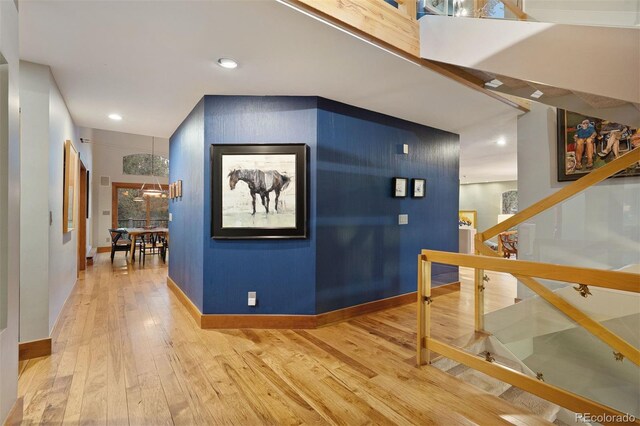 hall featuring wood-type flooring, baseboards, and recessed lighting