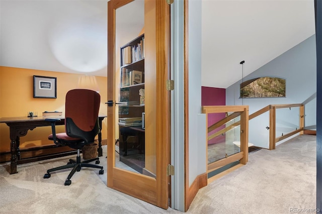 carpeted home office featuring lofted ceiling