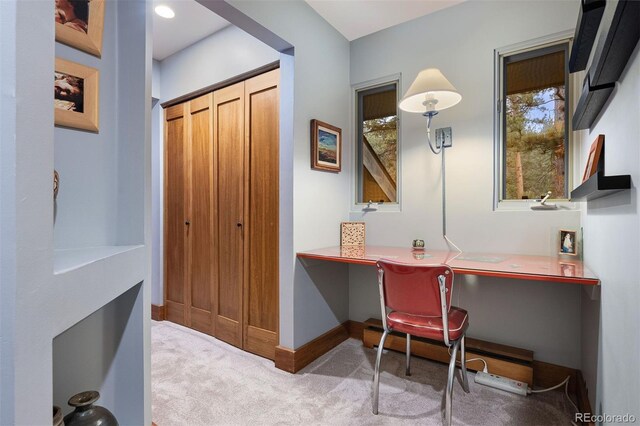 office space featuring a baseboard heating unit, carpet flooring, built in study area, and baseboards