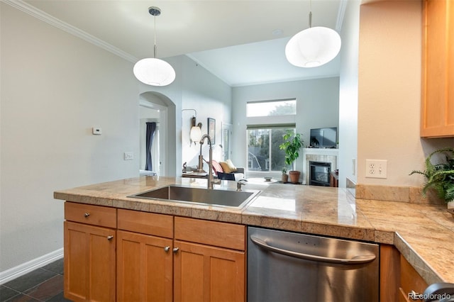 kitchen with kitchen peninsula, sink, a tile fireplace, decorative light fixtures, and dishwasher