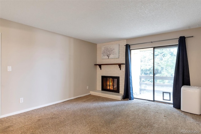 unfurnished living room with a brick fireplace, carpet, and a textured ceiling