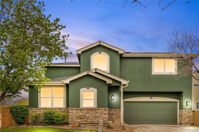 view of front of property with stone siding, stucco siding, a garage, fence, and driveway