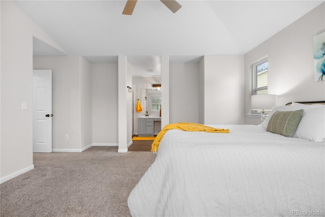 carpeted bedroom with baseboards, ensuite bathroom, and ceiling fan