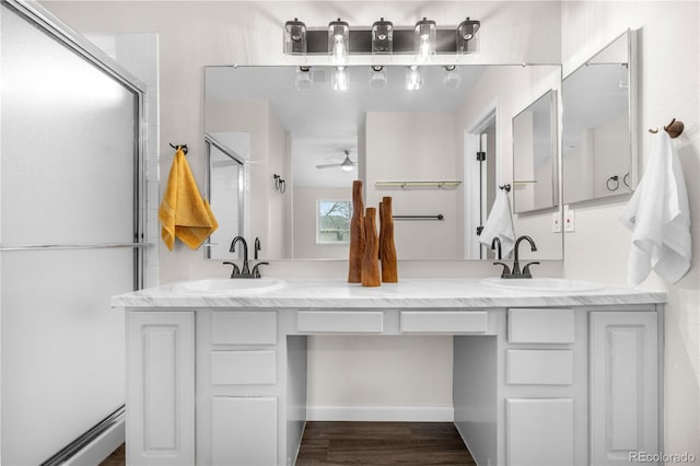 full bath with a ceiling fan, double vanity, wood finished floors, and a shower with shower door