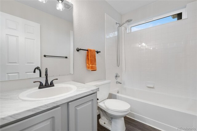 full bath featuring toilet, vanity, shower / bath combination, and wood finished floors