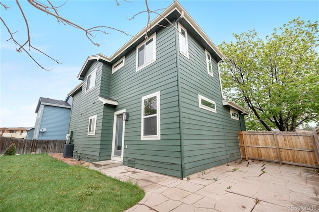 back of property with a patio area and central air condition unit