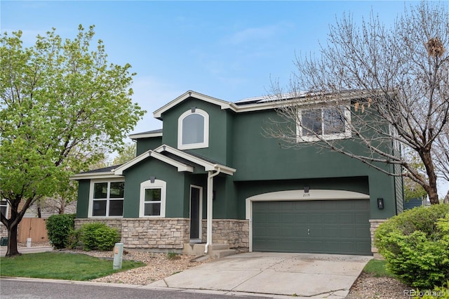 view of front of home featuring stone siding, stucco siding, driveway, a garage, and fence