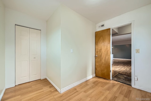 unfurnished bedroom featuring light wood-type flooring and a closet