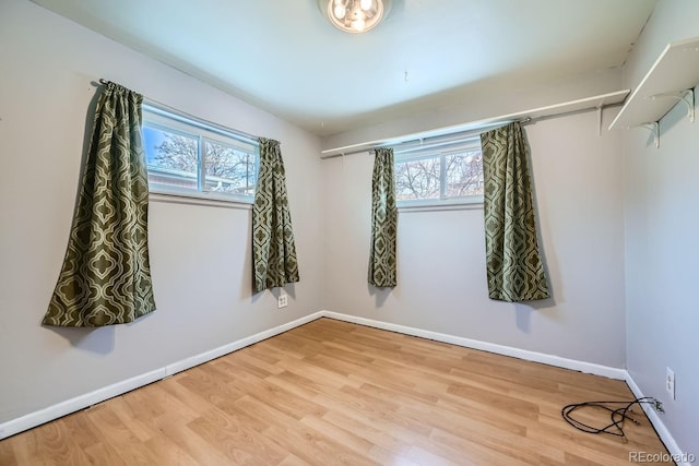 spare room with hardwood / wood-style floors and plenty of natural light