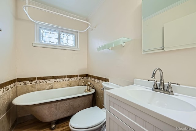 bathroom with a bathtub, vanity, crown molding, tile walls, and toilet