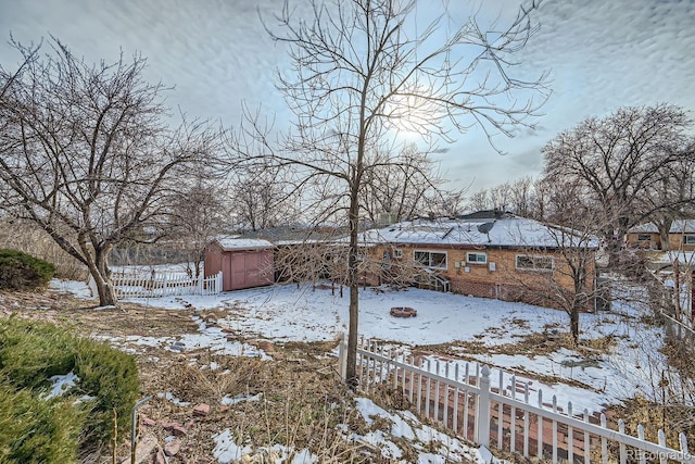 yard covered in snow with a storage unit