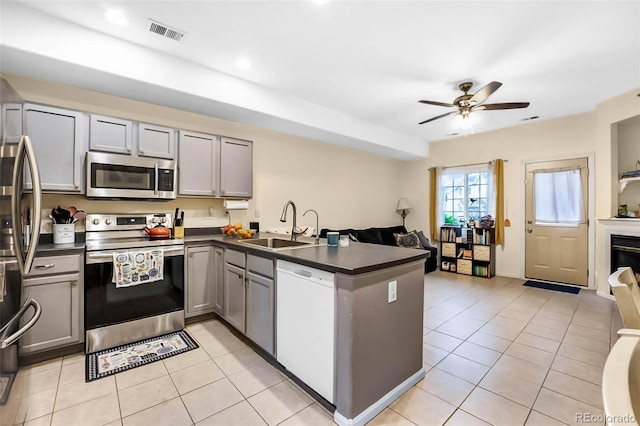 2143 Coronado Pkwy Unit C, Denver, CO 80229 - kitchen featuring stainless steel appliances, gray cabinets, a peninsula, dark countertops, and open floor plan