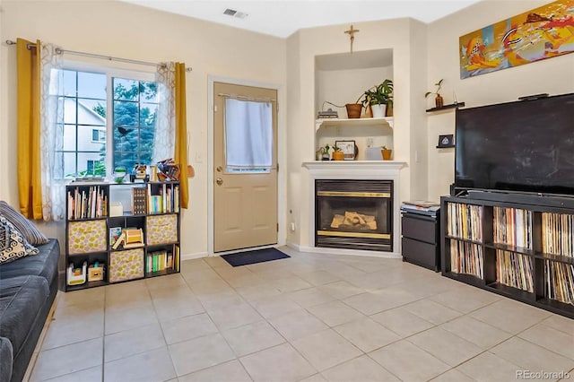 2143 Coronado Pkwy Unit C, Denver, CO 80229 - tiled living room featuring a glass covered fireplace and baseboards