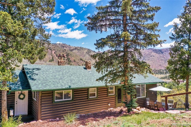 9850 Mohawk Trl, Cascade, CO 80809 - view of front of home featuring a mountain view, a chimney, and a shingled roof