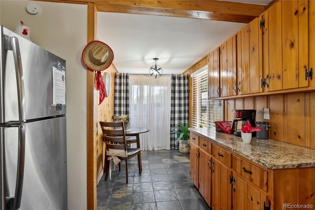 9850 Mohawk Trl, Cascade, CO 80809 - kitchen with freestanding refrigerator, stone tile floors, and brown cabinets