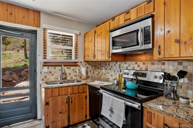 9850 Mohawk Trl, Cascade, CO 80809 - kitchen with appliances with stainless steel finishes, a sink, decorative backsplash, and light stone countertops