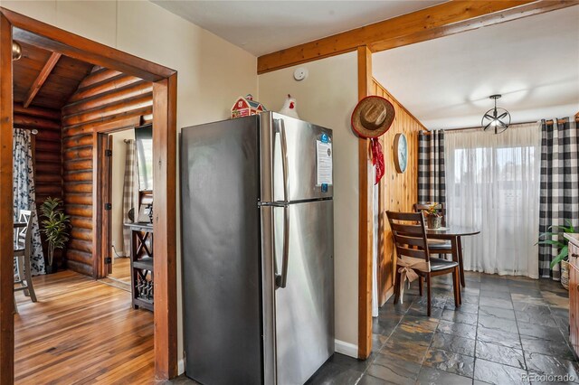9850 Mohawk Trl, Cascade, CO 80809 - kitchen featuring freestanding refrigerator, rustic walls, and baseboards