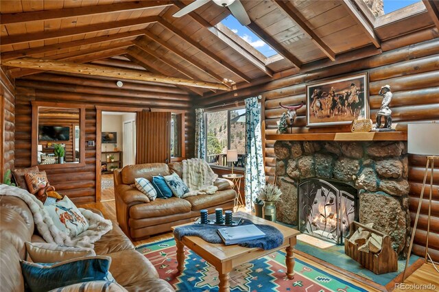 9850 Mohawk Trl, Cascade, CO 80809 - living area with a skylight, wood finished floors, wood ceiling, log walls, and a stone fireplace