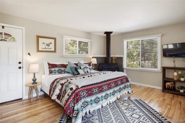 9850 Mohawk Trl, Cascade, CO 80809 - bedroom featuring wood finished floors, baseboards, and a wood stove