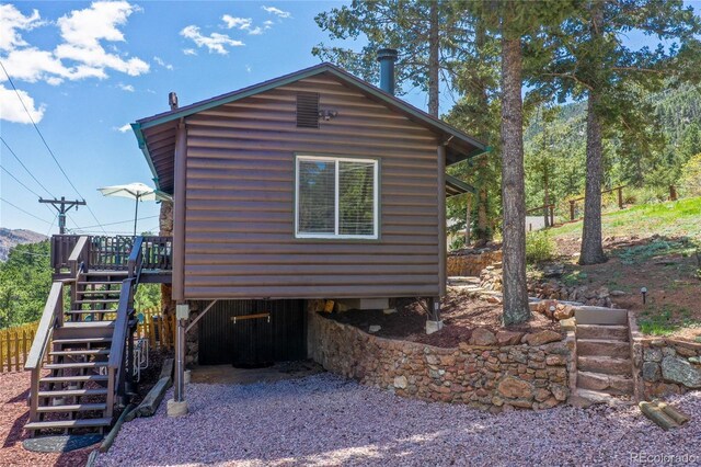 9850 Mohawk Trl, Cascade, CO 80809 - view of property exterior featuring stairway, a wooden deck, and log veneer siding