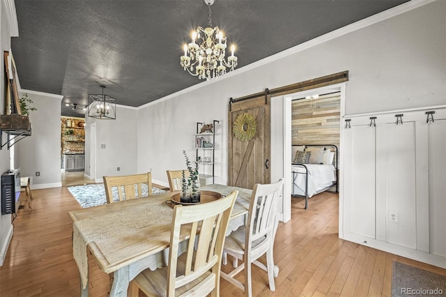 1024 34th St, Denver, CO 80205 - dining room featuring a chandelier, a barn door, light wood finished floors, ornamental molding, and a textured ceiling