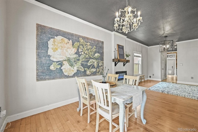 1024 34th St, Denver, CO 80205 - dining space with a chandelier, hardwood / wood-style floors, crown molding, and a textured ceiling