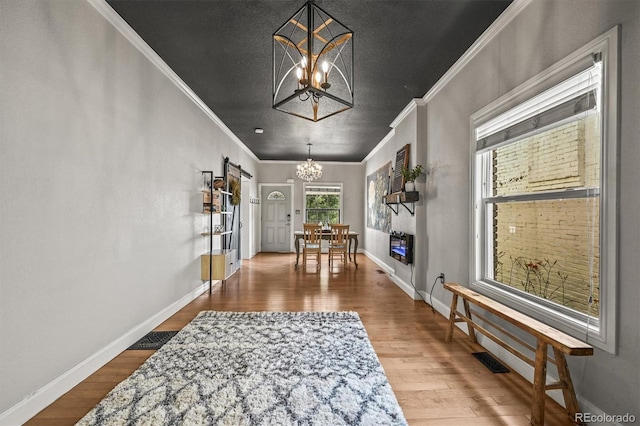 1024 34th St, Denver, CO 80205 - hall featuring a chandelier, crown molding, and wood finished floors