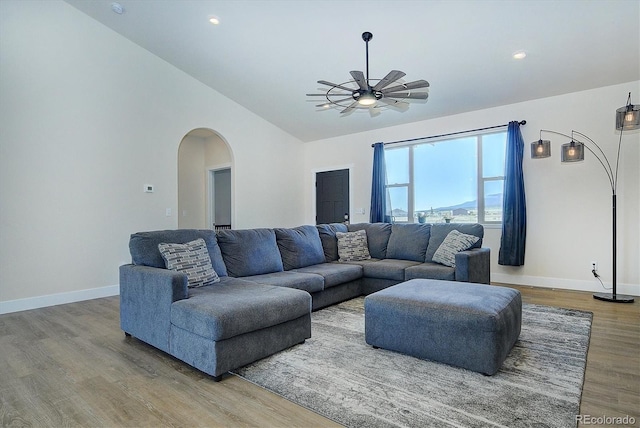 living room featuring ceiling fan, vaulted ceiling, and light hardwood / wood-style floors