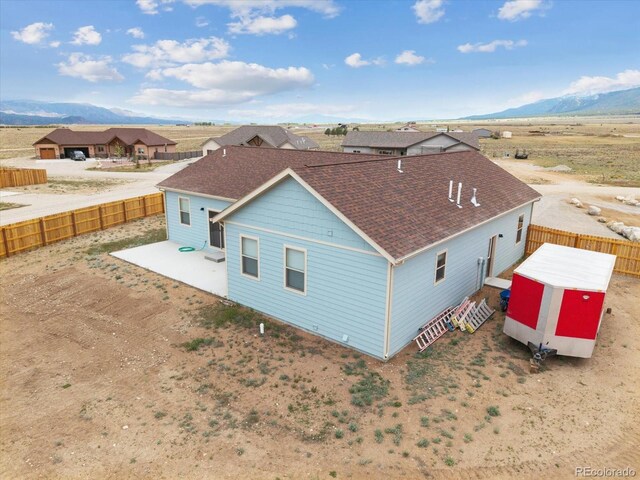 15626 Paintbrush St, Buena Vista, CO 81211 - rear view of house with roof with shingles, a mountain view, a fenced backyard, and a patio