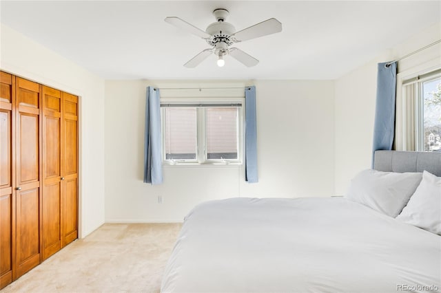 bedroom with a ceiling fan, baseboards, and light carpet