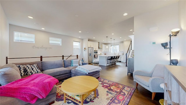 living room with plenty of natural light and dark hardwood / wood-style flooring