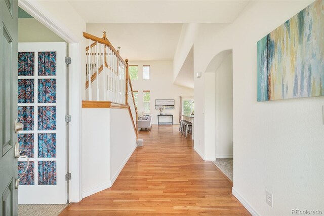 1477 Serene Dr, Erie, CO 80516 - corridor with light wood finished floors, stairway, baseboards, and arched walkways