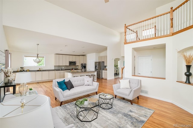 1477 Serene Dr, Erie, CO 80516 - living area featuring light wood-type flooring, a towering ceiling, and baseboards