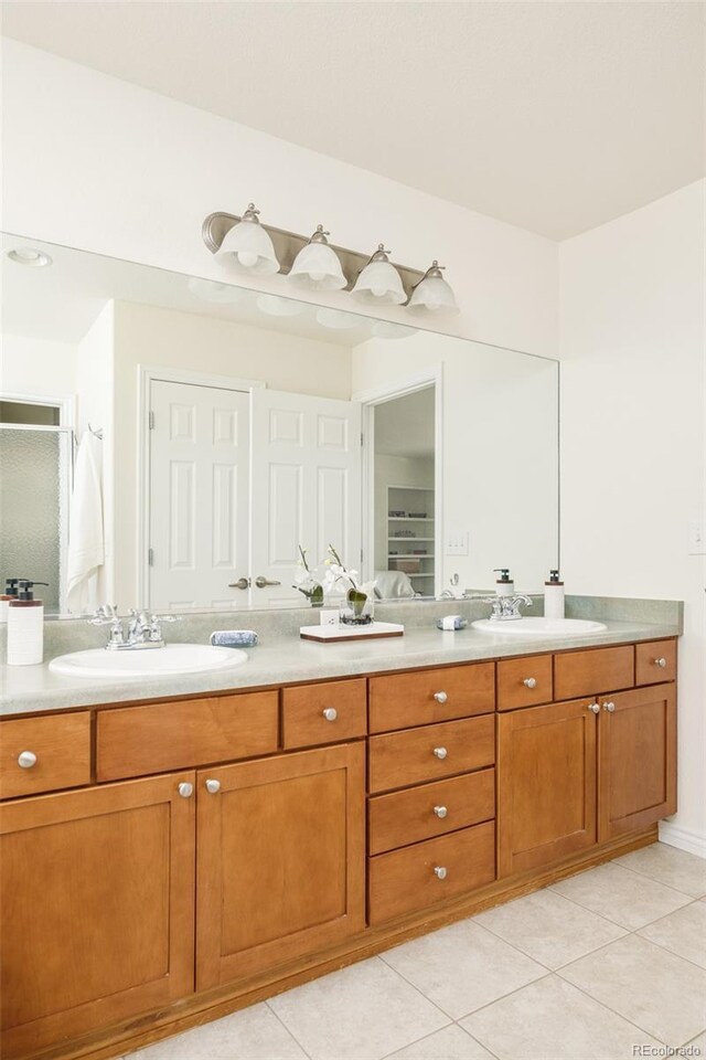 1477 Serene Dr, Erie, CO 80516 - bathroom with double vanity, tile patterned flooring, and an enclosed shower