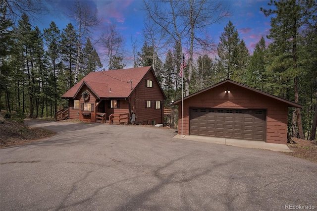 view of front of home featuring a garage and an outbuilding