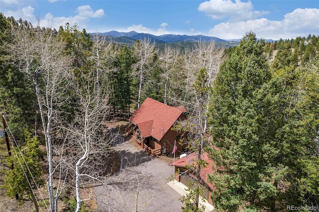 drone / aerial view featuring a forest view and a mountain view