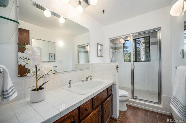 full bathroom featuring toilet, a shower stall, wood finished floors, and vanity