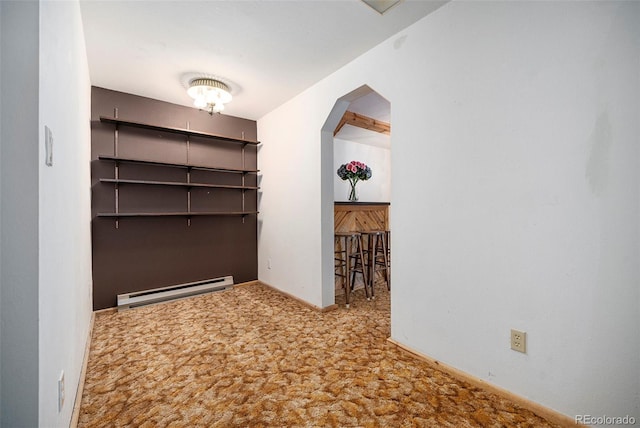 hall with baseboards, a baseboard radiator, carpet, and arched walkways