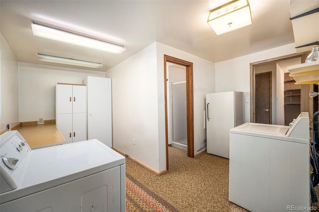laundry room with baseboards, carpet floors, washing machine and dryer, and cabinet space